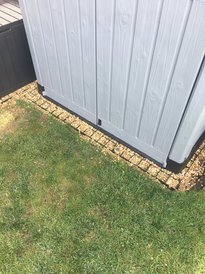 Plastic shed sitting on top of recycled plastic shed base grids